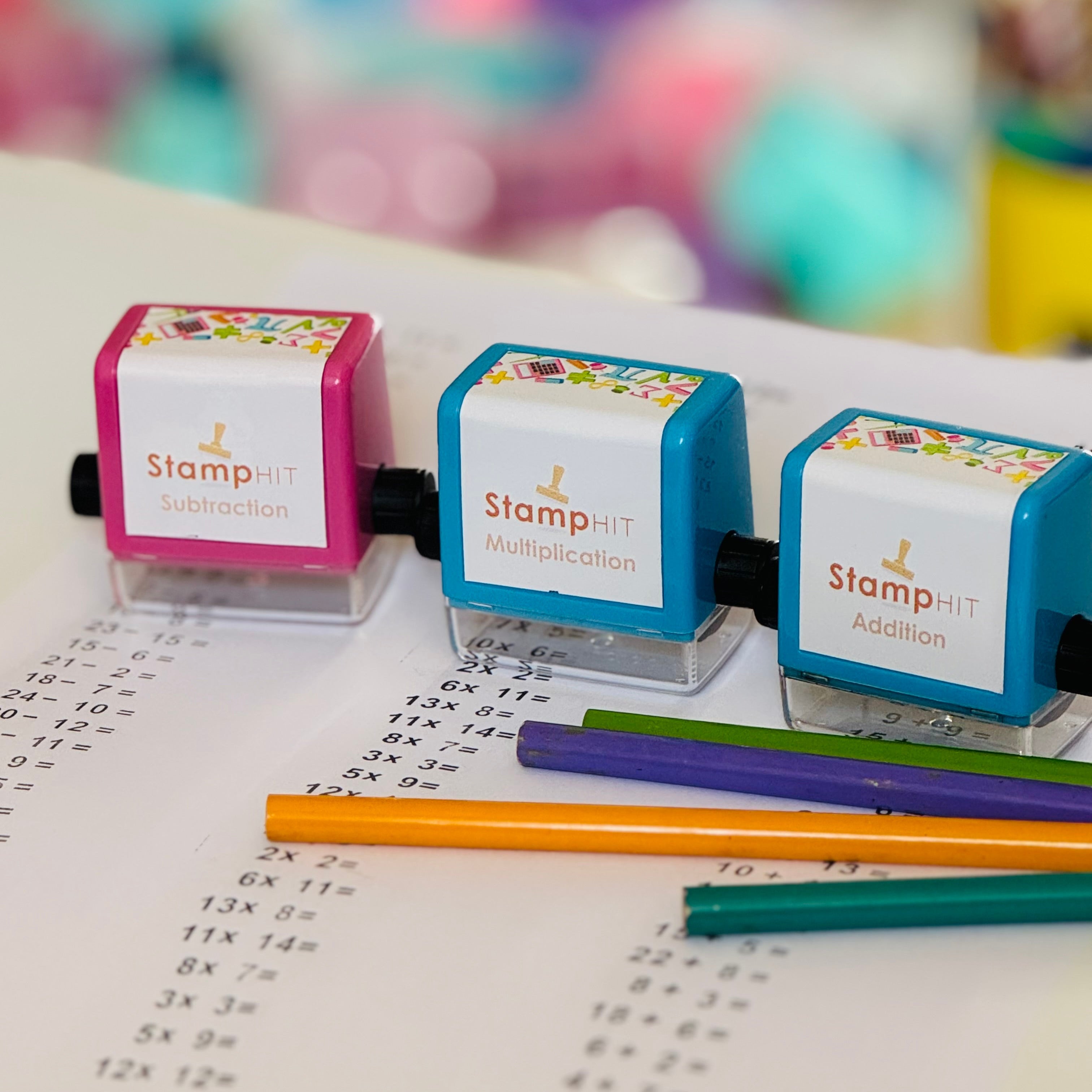 Three math stamps sitting on paper with pencils