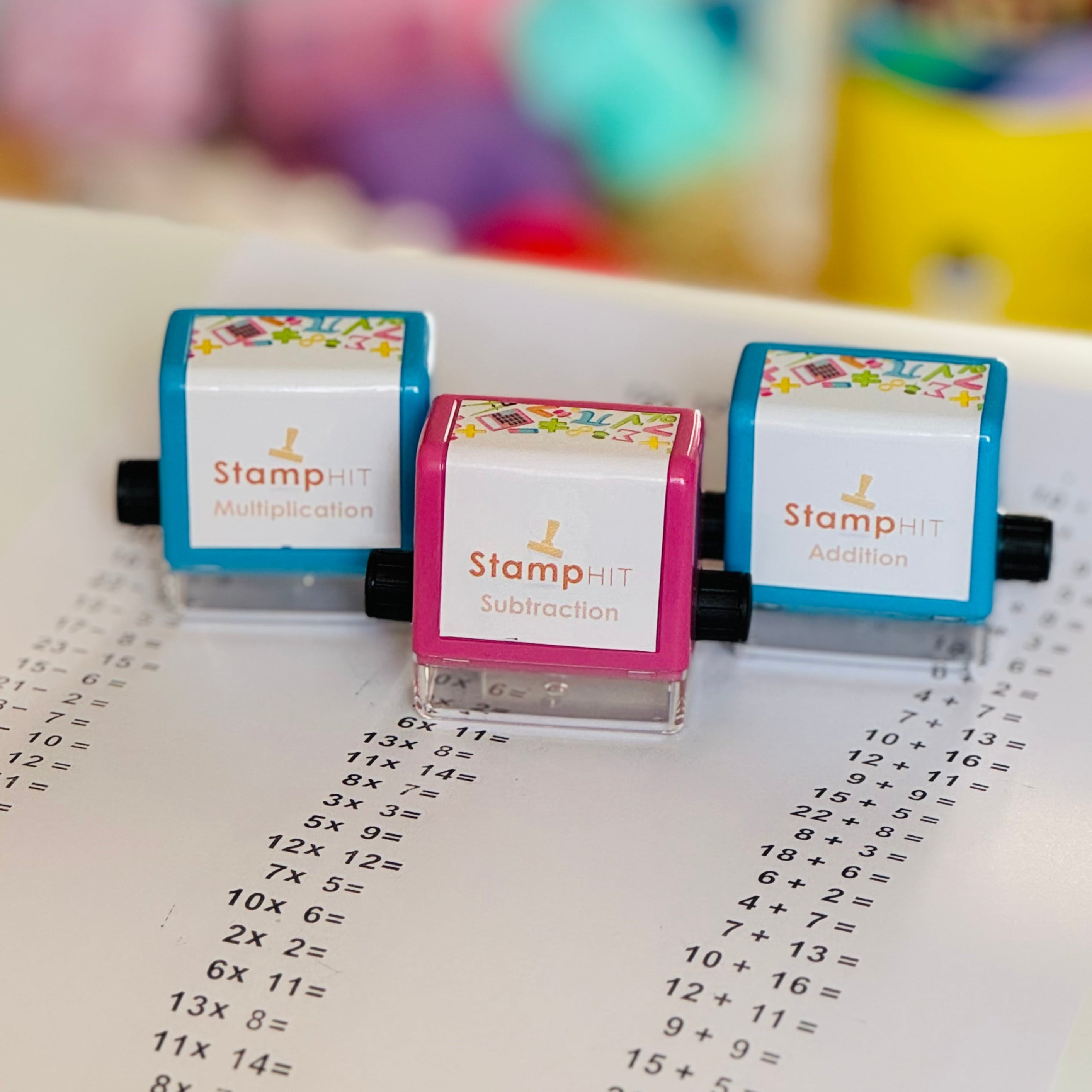 Three math stamps sitting on paper with math problems