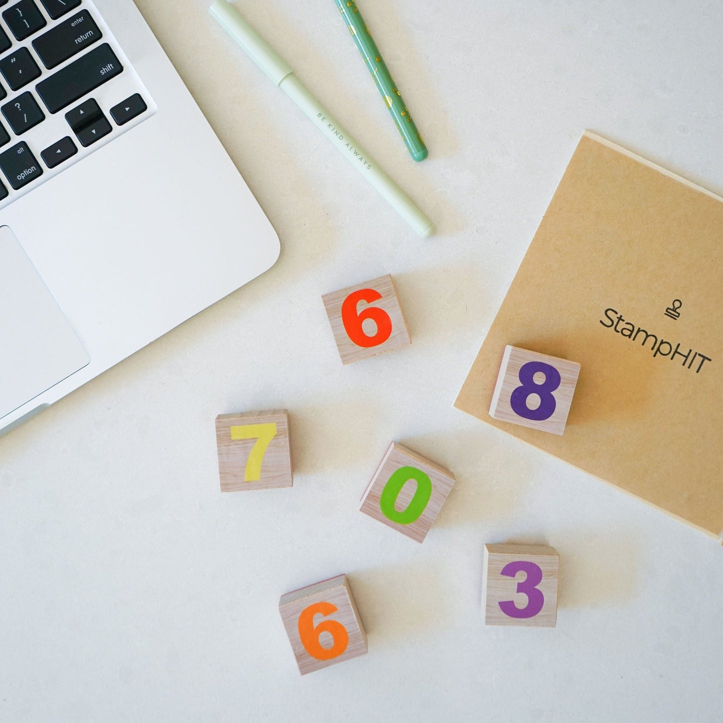 Multiple square number stamps sitting next to a sheet with StampHIT printed in the middle