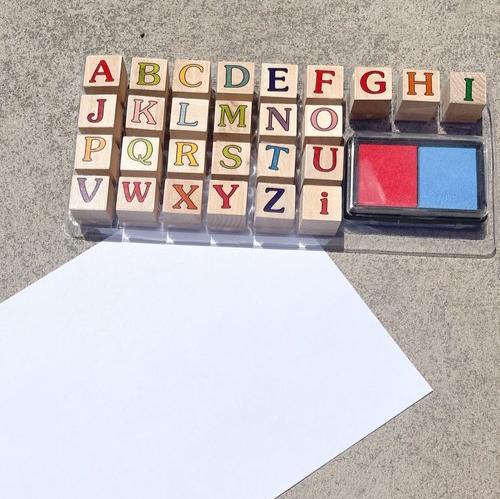 An assortment of educational alphabet stamps sitting neatly next to a sheet of paper