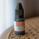 Black fabric ink refill bottle sitting upright with the stampHIT logo on the front