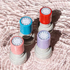Four clock stamps standing upright beside each other. Each of them displaying an analogue clock face without the minute or hour hands on the top