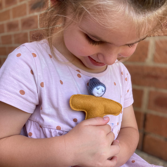 A little girl cuddles a soft stamp toy