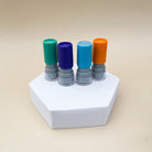 Green, purple, light blue and orange card stamps sitting atop a pentagonal prism