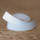 A piece of white fabric labelling tape curled up